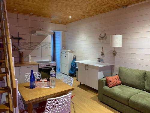 a kitchen and a living room with a couch and a table at Chalet Élise Plein centre ville in Gérardmer