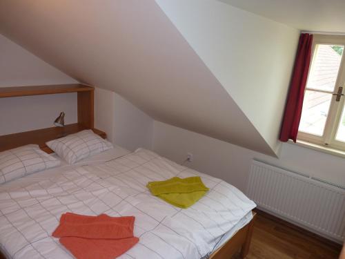 a bedroom with a bed with two towels on it at Penzion U Houšků in Stráž nad Nežárkou