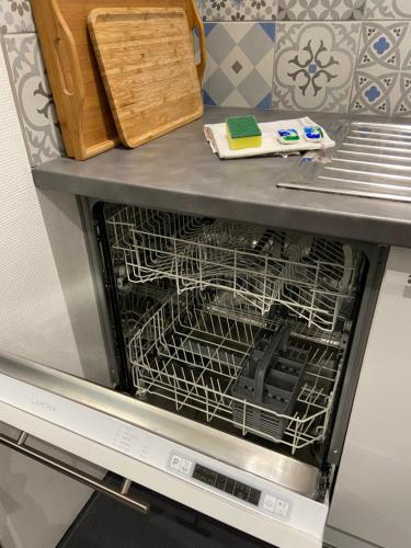 a dishwasher with a dish rack inside of it at Studio (Coup de Coeur) Wimereux in Wimereux