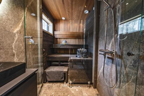 y baño con ducha y cabina de ducha acristalada. en Levin Hurma, en Levi