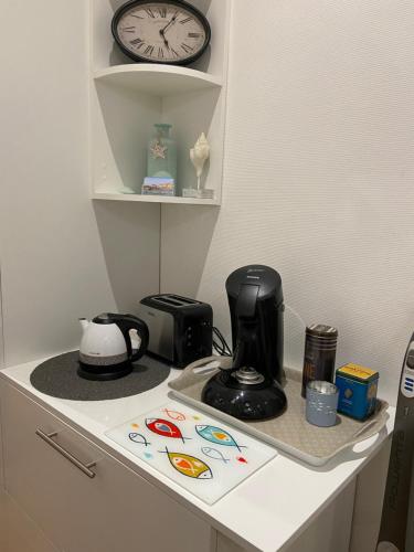 a kitchen counter with a coffee maker and a clock at Studio (Coup de Coeur) Wimereux in Wimereux