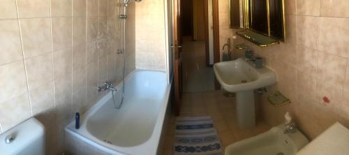 La salle de bains est pourvue d'un lavabo, d'une baignoire et de toilettes. dans l'établissement Condominio Il Rustico, à Aoste
