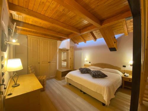 1 dormitorio con cama, mesa y escritorio en Principessa Giovanna Boutique Chalet en Roccaraso