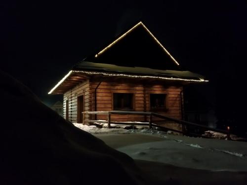 a log cabin with lights on the roof in the snow at Chata Líška JASNA in Liptovský Mikuláš