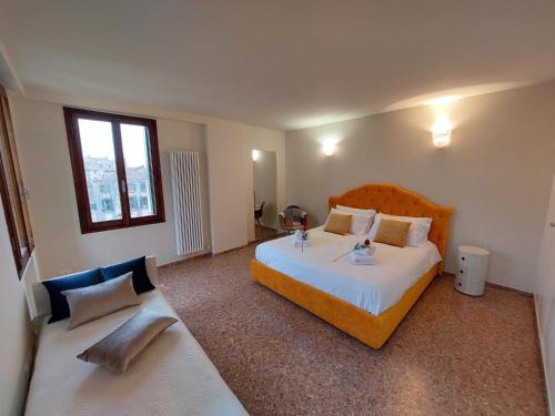 una camera da letto con un letto grande e un divano di Ca' Francesca Suite Terrace in Venice a Venezia