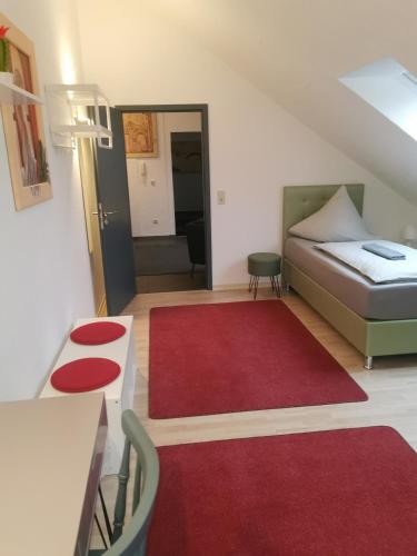 a small room with a bed and a red rug at Rimvydas Apartment in Winterberg