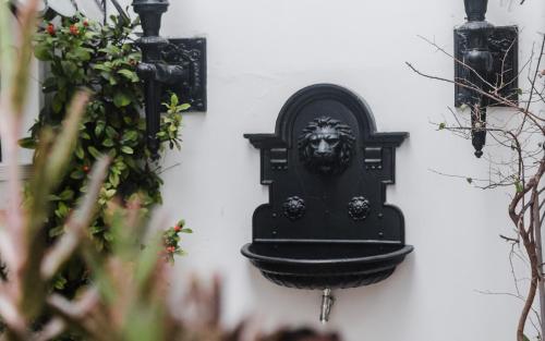 a black door with a lion head on a wall at Vilarejo - Centro Histórico Ilhabela in Ilhabela