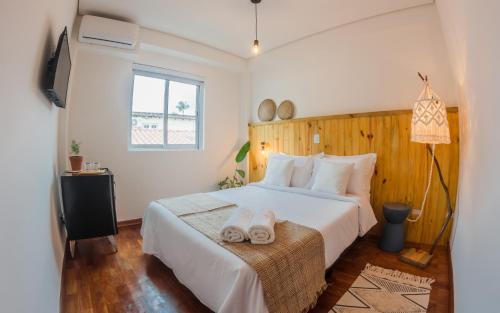 A bed or beds in a room at Vilarejo - Centro Histórico Ilhabela