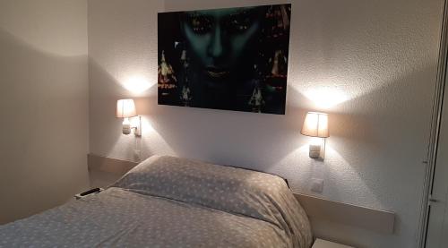 ein Schlafzimmer mit einem Bett und zwei Lampen an der Wand in der Unterkunft Superbe appartement piscine centre port - belle vue - parking in Cap d'Agde