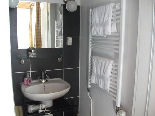 une salle de bain avec un lavabo et un miroir dans l'établissement La Mirabelle, à Cornimont