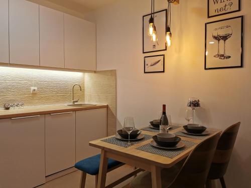 a kitchen with a table with chairs and a sink at Apartman Maximus in Vrnjačka Banja