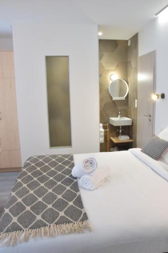 - une chambre avec un lit blanc, un lavabo et un miroir dans l'établissement Studio cosy black - Cosy & Cocon, à Mulhouse