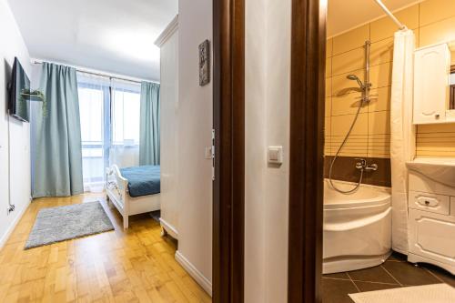 Un baño con ducha, lavabo y bañera. en Apartament Maza, en Sinaia