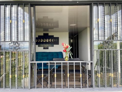 a vase of flowers sitting on a table in front of a window at BERAKHAH SPA & ROOMS in Guatapé