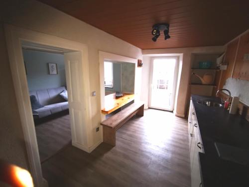 a kitchen and living room with a couch and a television at Mooi ruim appartement in antieke stadsboerderij in Schönecken