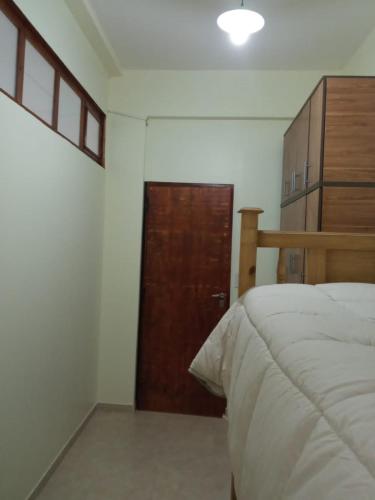 a bedroom with a bed and a wooden door at Casa Huerta in Vista Flores