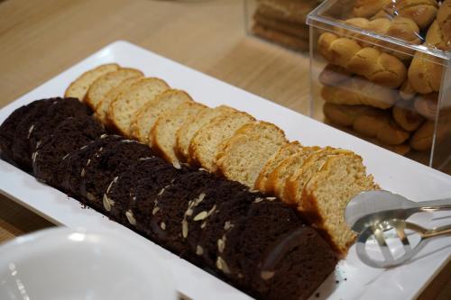 a white plate with a loaf of bread and a knife at Hotel Antoniadis in Kalabaka