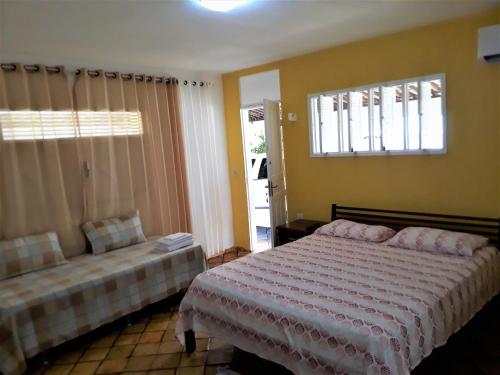 1 dormitorio con cama y sofá en Girassol Pousada, en Extremóz