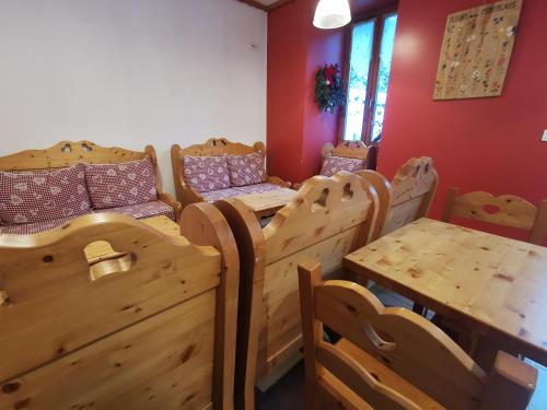 Habitación con cama de madera, mesa y sillas. en Auberge du Freney en Le Freney-dʼOisans
