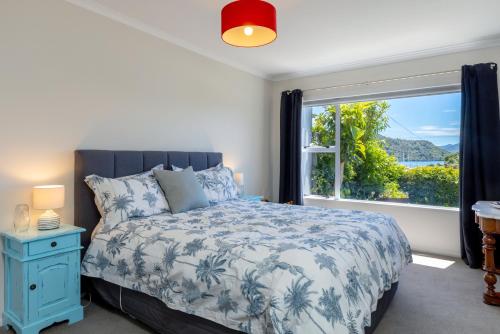 um quarto com uma cama e uma grande janela em Seaview Apartment em Picton