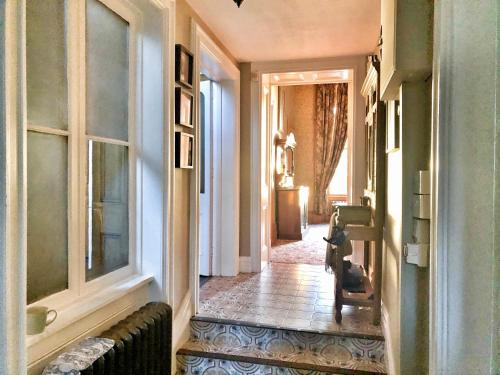 un pasillo con una habitación con ventanas y una silla en Edmondstown House, en Ballaghaderreen