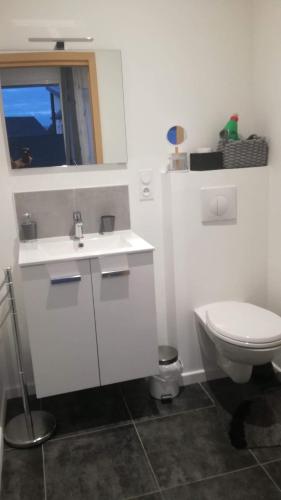 a white bathroom with a toilet and a sink at La casita de Vanessa in Changé