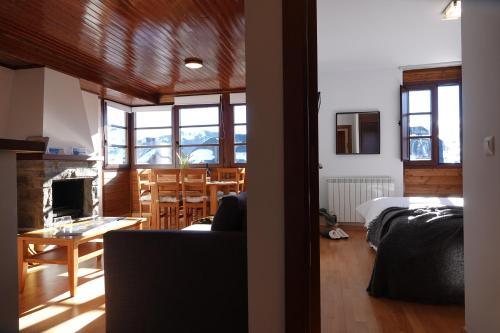 una sala de estar con una cama y una habitación con una mesa. en ❅ Pirineos360 ❅ Stone · Garaje cubierto y Trastero, en Formigal