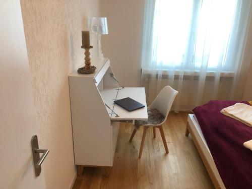 a bedroom with a desk with a laptop and a bed at Ferienwohnung nähe Flumserberg Ski Wandergebiet in Filzbach