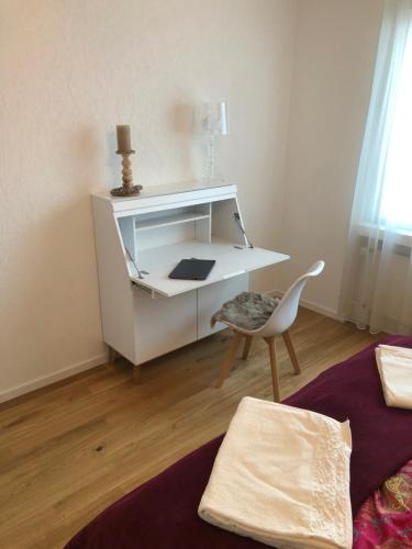 a white desk in a room with a chair at Ferienwohnung nähe Flumserberg Ski Wandergebiet in Filzbach
