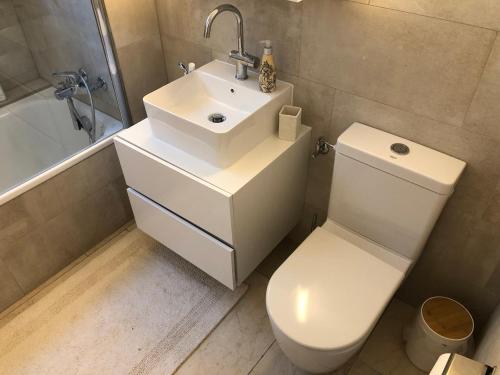 a bathroom with a white toilet and a sink at Ferienwohnung nähe Flumserberg Ski Wandergebiet in Filzbach