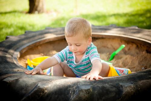 a little boy playing in a sandbox in a play tub at Rozmaring Vendégház in Zengővárkony