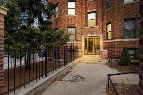un edificio de ladrillo con una valla delante en Delightful 1BR Apartment in Ravenswood - Ashland BW, en Chicago