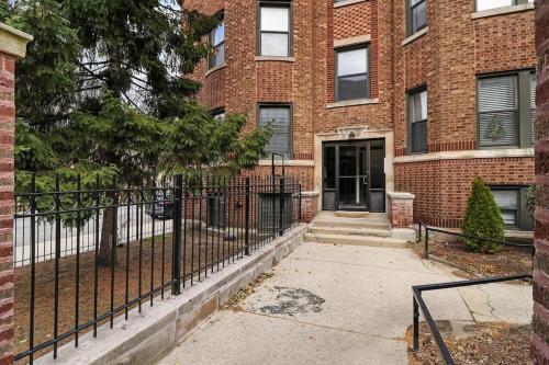 un edificio de ladrillo con una valla delante en Delightful 1BR Apartment in Ravenswood - Ashland BW en Chicago