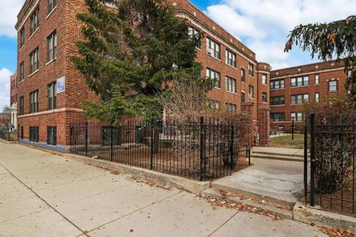 una cerca negra frente a un edificio de ladrillo en Delightful 1BR Apartment in Ravenswood - Ashland BW en Chicago