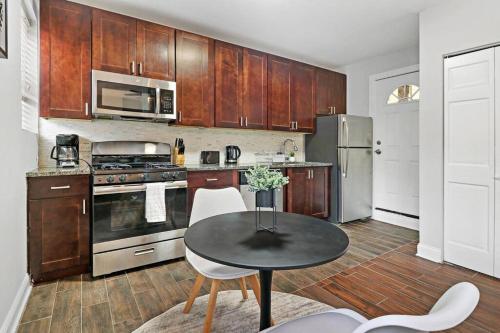 una cocina con armarios de madera y una mesa con sillas. en Delightful 1BR Apartment in Ravenswood - Ashland BW en Chicago