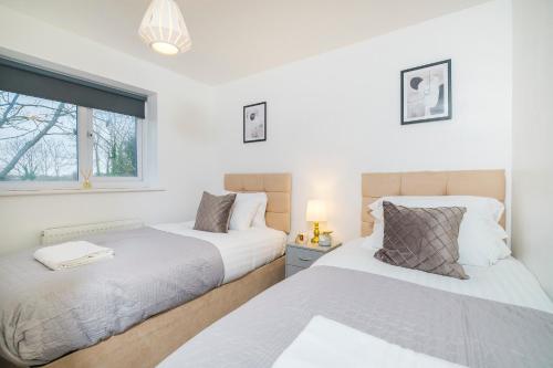 deux lits dans une chambre avec une fenêtre dans l'établissement Beautiful 3 Bed House with Amazing Views in Dartford, Kent, à Kent