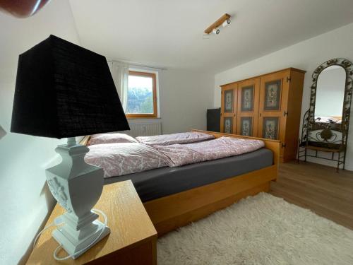 a bedroom with a bed and a lamp on a table at Alpenauszeit in (den) Bergen in Bergen
