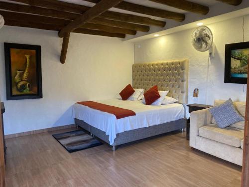a bedroom with a large bed and a couch at Hotel Santos De Piedra - MARANATHA BARICHARA in Barichara