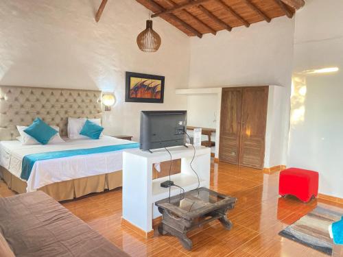 a bedroom with a bed and a tv in a room at Hotel Santos De Piedra - MARANATHA BARICHARA in Barichara
