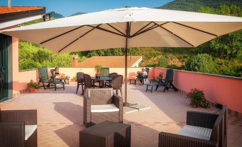 een patio met een parasol en tafels en stoelen bij Residence Gli Ulivi di Eolo in Sapri