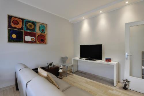 a white living room with a white couch and a tv at Casarimidia in Perugia