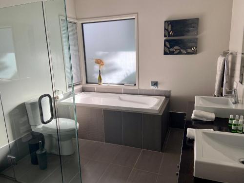 a bathroom with a tub and a sink and a window at Queenstown Lake Panorama in Queenstown