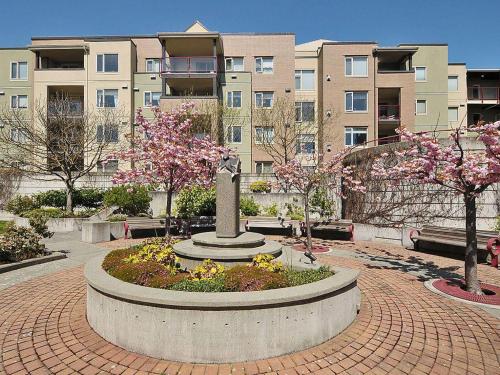 a park with a statue in front of a building at Deluxe 2 Bed 2 Bath With Harbour And Empress Hotel Views in Victoria