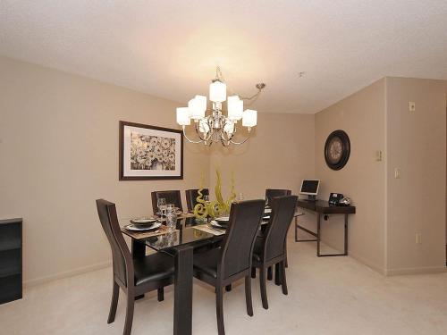 a dining room with a black table and chairs at Deluxe 2 Bed 2 Bath With Harbour And Empress Hotel Views in Victoria