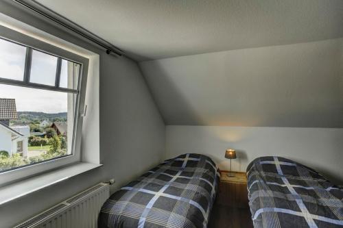 two beds in a room with a window at Villa Meisen in Medebach