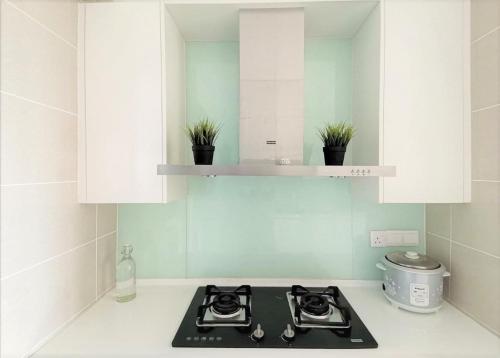 a kitchen with white cabinets and a stove top oven at Iskandar Residences 3 Bedroom in Nusajaya