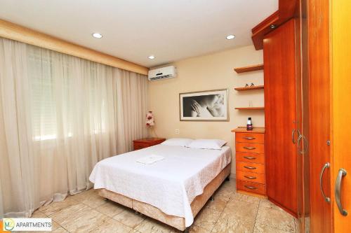 1 dormitorio con 1 cama, vestidor y ventana en Apartamento espaçoso e luxuoso em Copacabana, en Río de Janeiro