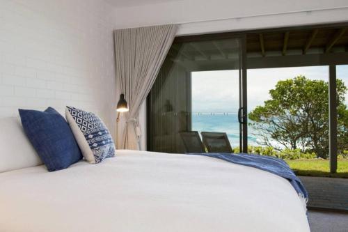 a bedroom with a bed with a view of the ocean at Fuller Holidays - Jane's on Wategos Unit 2, 37 Marine Pde-2 Bed Villa in Byron Bay