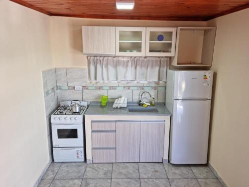 a small kitchen with a refrigerator and a sink at ITURANCH in Ituzaingó