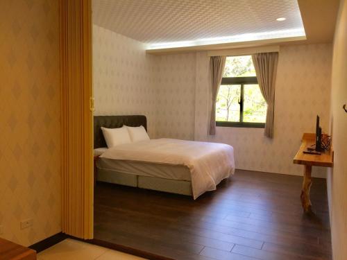 a bedroom with a bed and a window at 微楓民宿 可加購晚餐酸白菜火鍋 in Renai